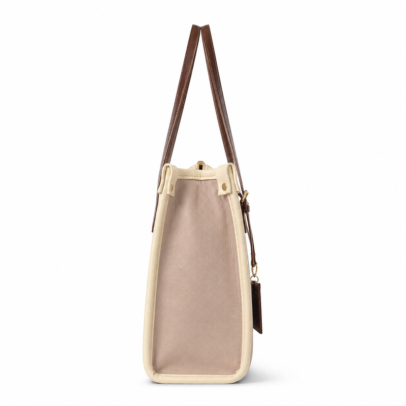 A structured tote bag with a dusty pink canvas body, cream-colored trim, and dark brown leather shoulder straps, shown from a side profile view on a white background.
